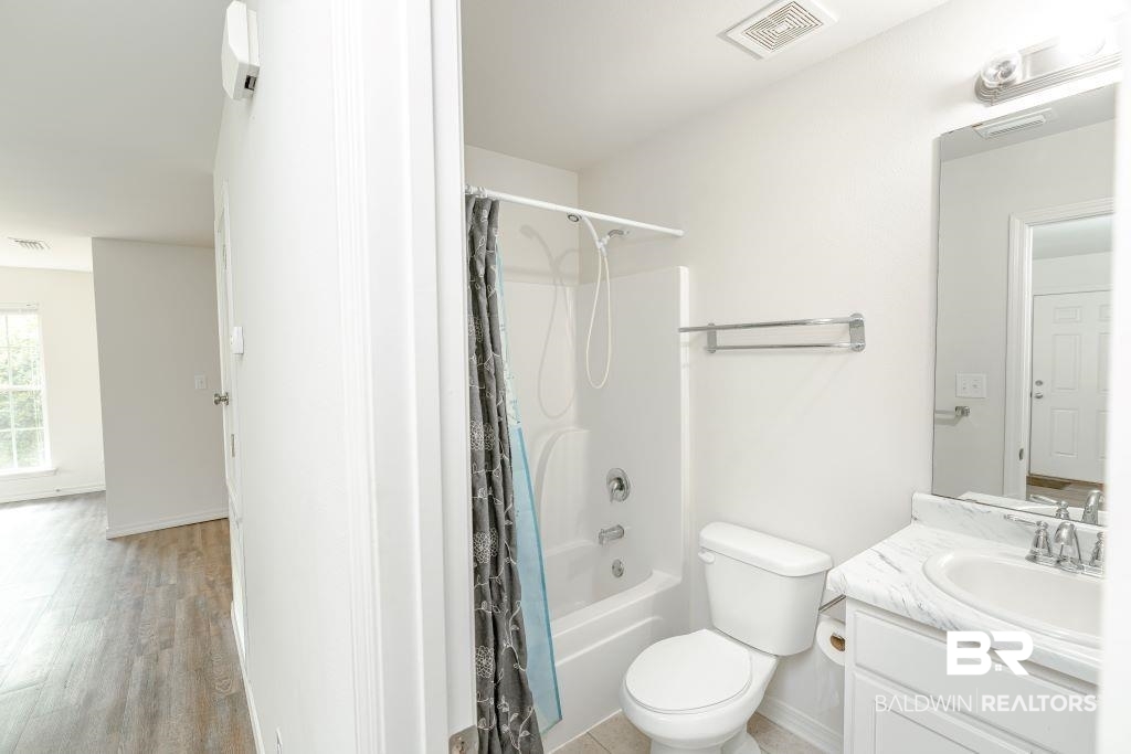 12641 Pecan Street Grand Bay, AL 36541 - Photo 17 of 23 Full bathroom with hardwood / wood-style floors, vanity, shower / bath combo with shower curtain, and toilet