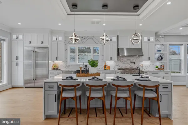a living room with furniture a table and kitchen view