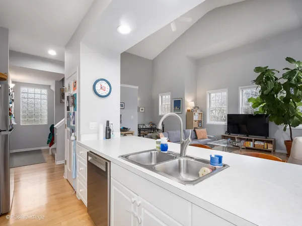 a kitchen with a sink a counter and a view of living room