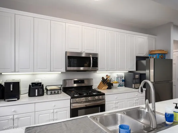 a kitchen with stainless steel appliances granite countertop a sink stove and refrigerator