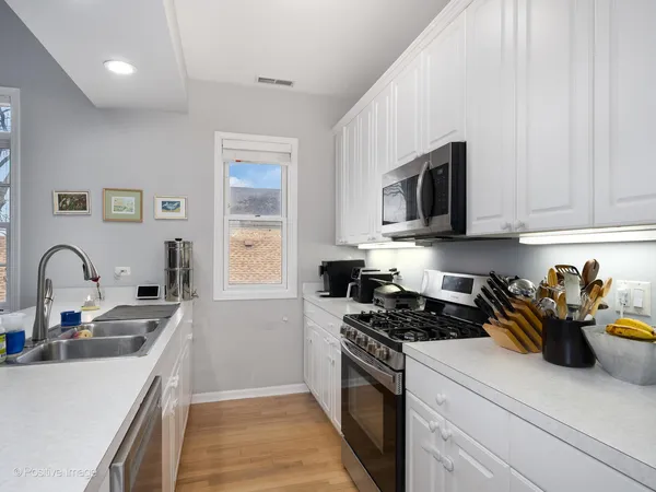 a kitchen with stainless steel appliances granite countertop a sink a stove top oven a counter space and cabinets