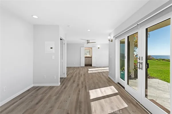 a view of a hall with wooden floor and door