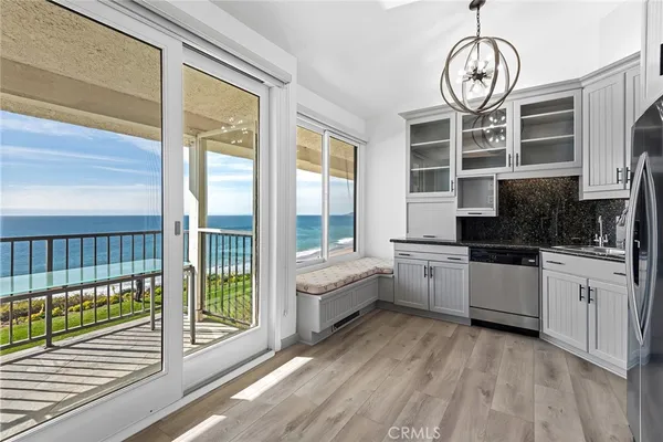 a kitchen with a large window and a wooden floor