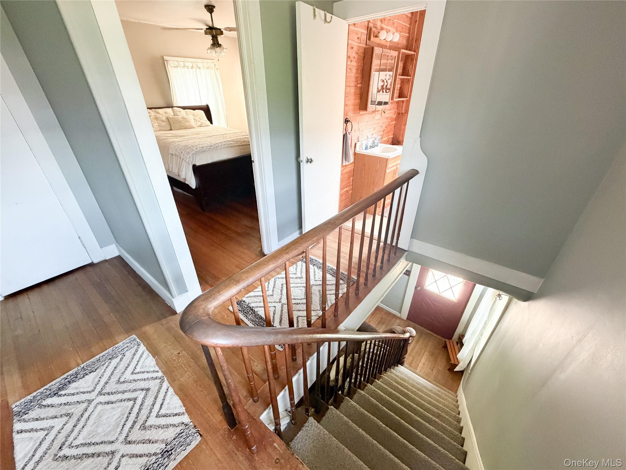 77 Rockland Road Roscoe, NY 12776 - Photo 13 of 20 Staircase featuring a wood-finish bannister and carpeted treads