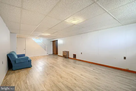 a view of a livingroom with wooden floor and furniture
