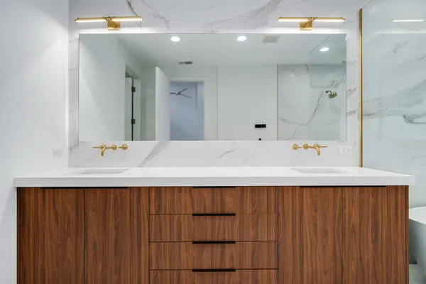 a bathroom with a double vanity sink toilet and shower