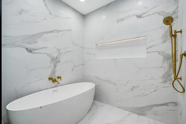 a bathroom with a tub a sink and a mirror