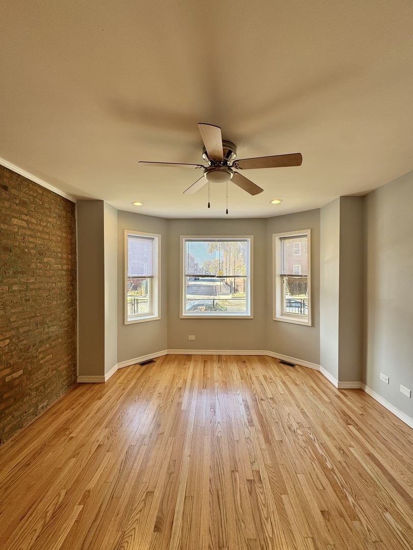1263 North Springfield Avenue, Unit 1 Chicago, IL 60651 - Photo 2 of 9 a view of an empty room with a window and wooden floor