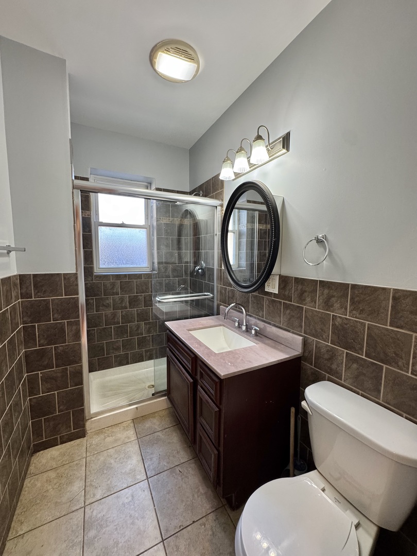 1263 North Springfield Avenue, Unit 1 Chicago, IL 60651 - Photo 7 of 9 a bathroom with a toilet a sink and a mirror
