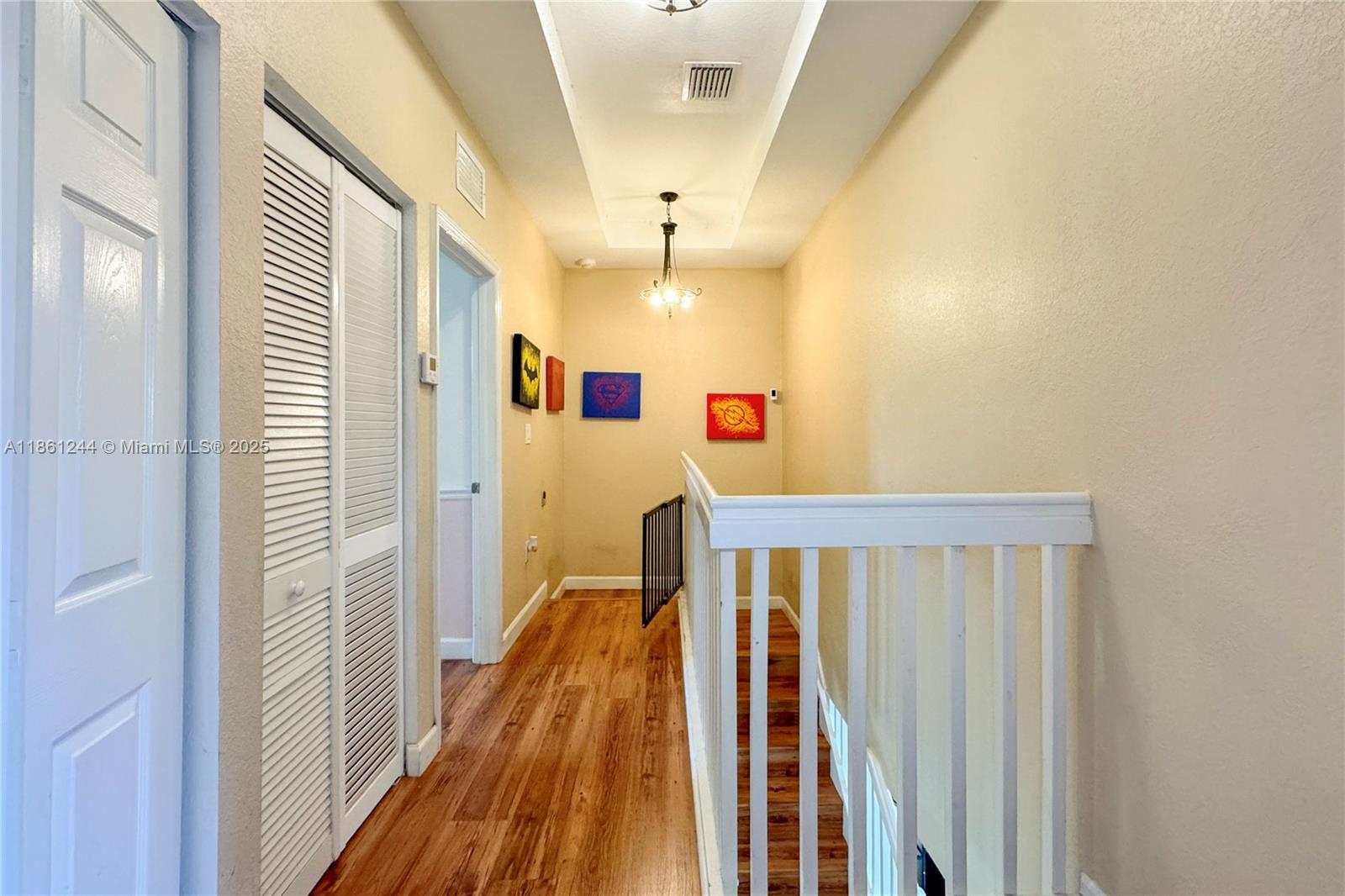 23745 Southwest 114 Court Homestead, FL 33032 - Photo 24 of 30 a view of a hallway with wooden floor and chandelier
