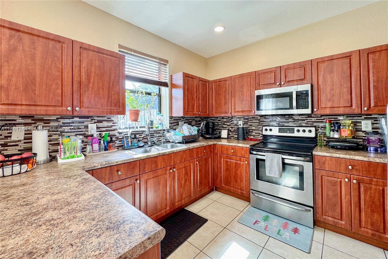 23745 Southwest 114 Court Homestead, FL 33032 - Photo 9 of 30 a kitchen with stainless steel appliances granite countertop a stove a sink dishwasher and a microwave oven with cabinets