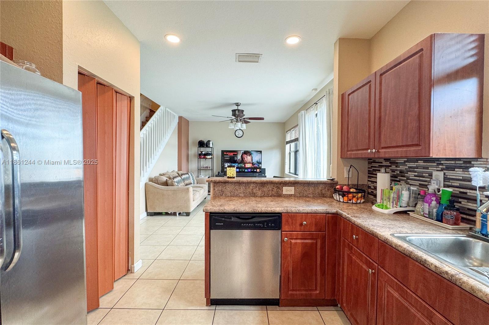 23745 Southwest 114 Court Homestead, FL 33032 - Photo 10 of 30 a kitchen with stainless steel appliances granite countertop a sink a stove and a refrigerator