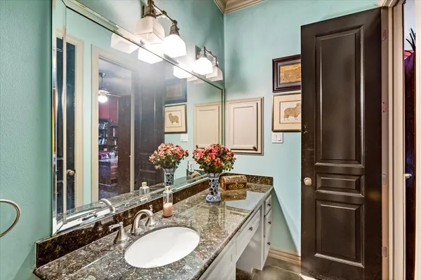 a bathroom with a granite countertop sink a mirror and a shower