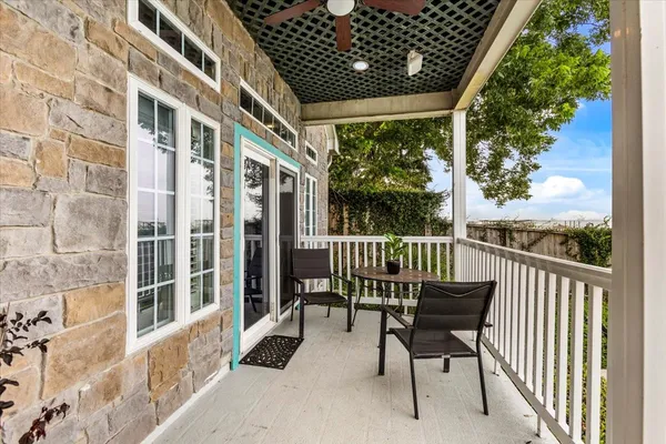 a balcony view with a large window and outdoor seating