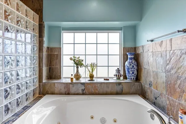 a view of a bathroom with a tub and a large window