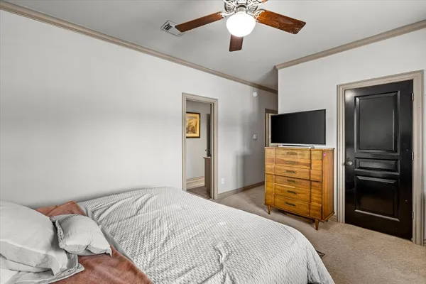 a bedroom with a bed and a flat tv screen on a dresser