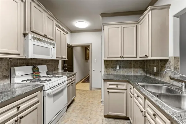 a kitchen with stainless steel appliances granite countertop a refrigerator sink and stove