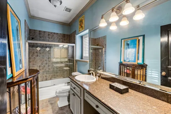 a bathroom with a granite countertop sink a mirror and a shower