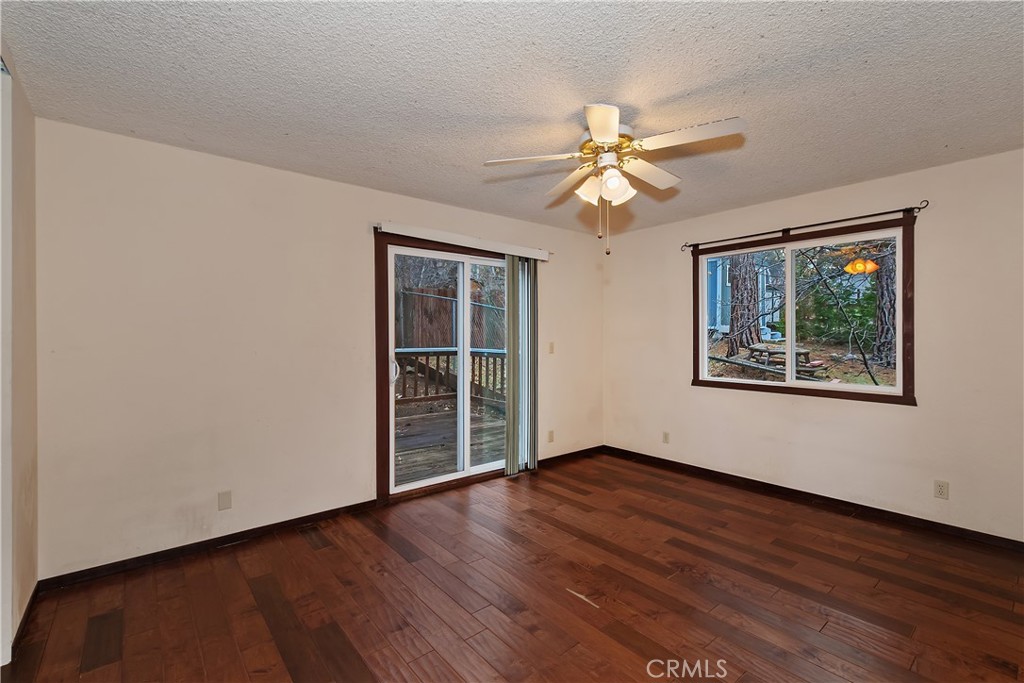 245 Vista Sugarloaf, CA 92386 - Photo 12 of 50 a view of empty room with wooden floor and fan
