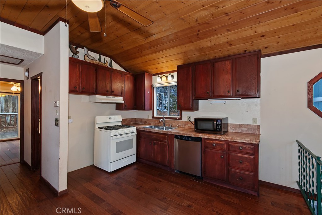 245 Vista Sugarloaf, CA 92386 - Photo 20 of 50 a kitchen with granite countertop wooden floors and stainless steel appliances