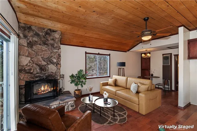 a view of an empty room with wooden floor fireplace and a window