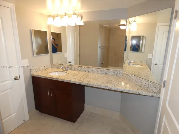 a bathroom with a granite countertop sink and a mirror