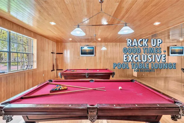 a room with pool table and windows