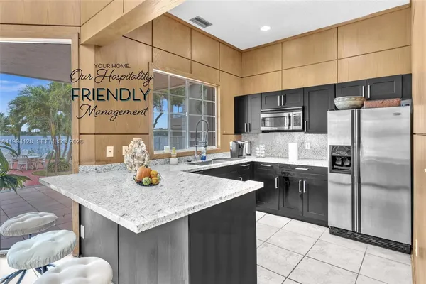 a kitchen with stainless steel appliances granite countertop a sink and a refrigerator