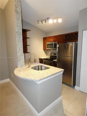 a kitchen with stainless steel appliances granite countertop refrigerator sink and stove