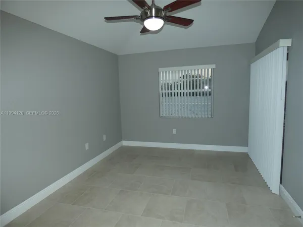 an empty room with a window and a fan