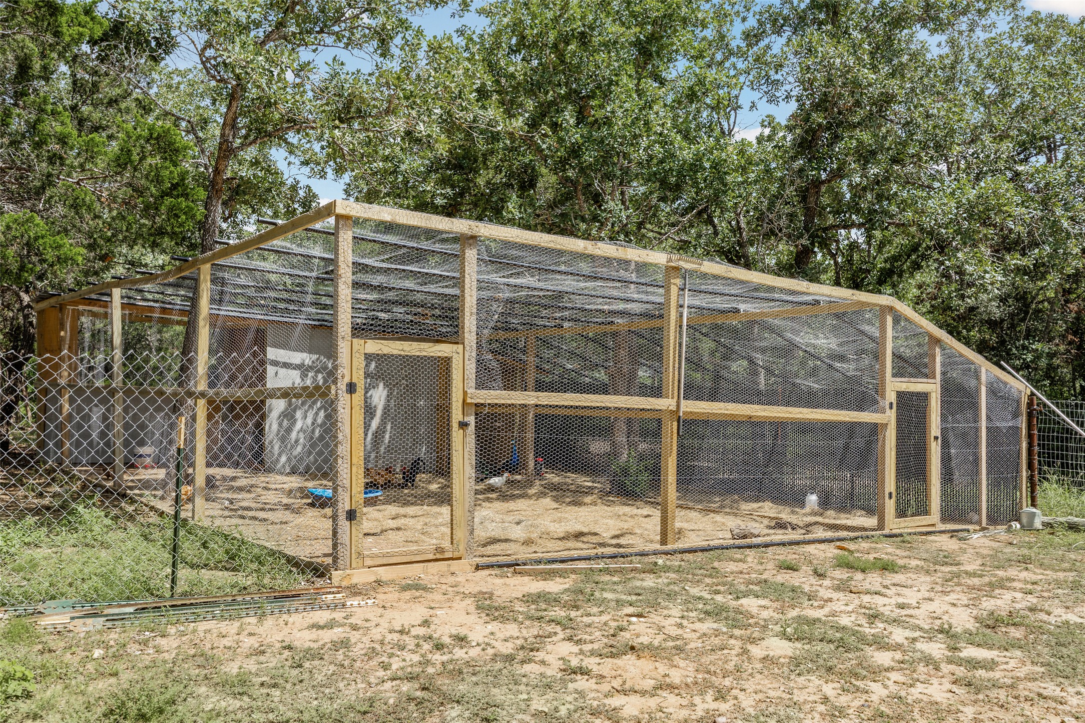 564 Boyd Road Red Rock, TX 78662 - Photo 10 of 25 A spacious, enclosed poultry coop offers secure housing for fowl amidst natural surroundings.