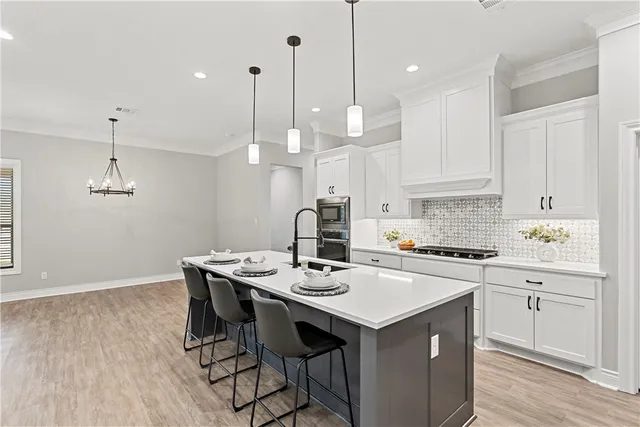 a kitchen with a sink a stove cabinets and wooden floor