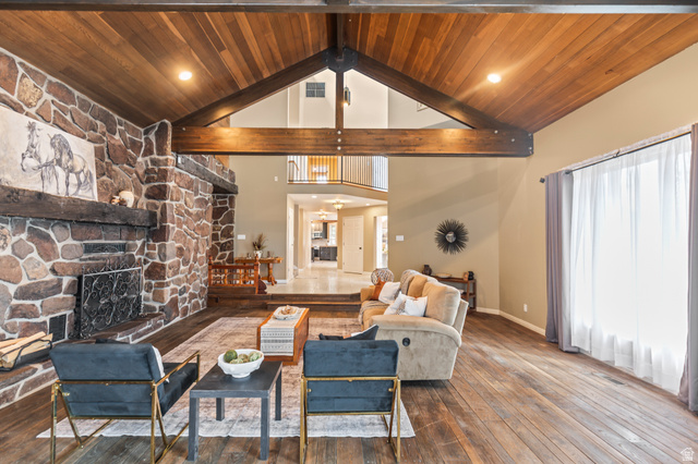460 Omni Point Road Central Valley, UT 84754 - Photo 11 of 101 Great room featuring a vaulted wood-paneled ceiling with exposed beams, a floor-to-ceiling natural stone fireplace, and 3/4 oak hardwood floors