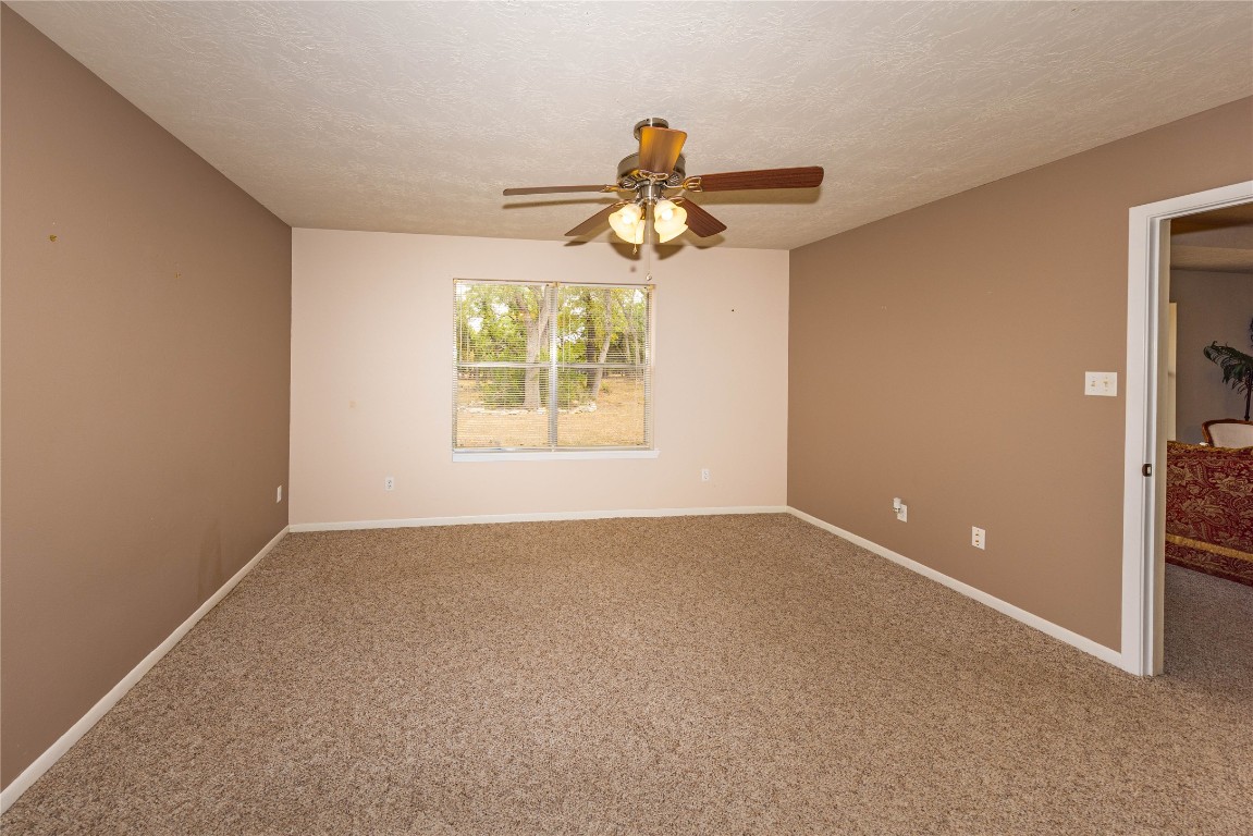 2501 Fischer Store Road Wimberley, TX 78676 - Photo 20 of 37 Empty room with carpet flooring, a textured ceiling, and a ceiling fan
