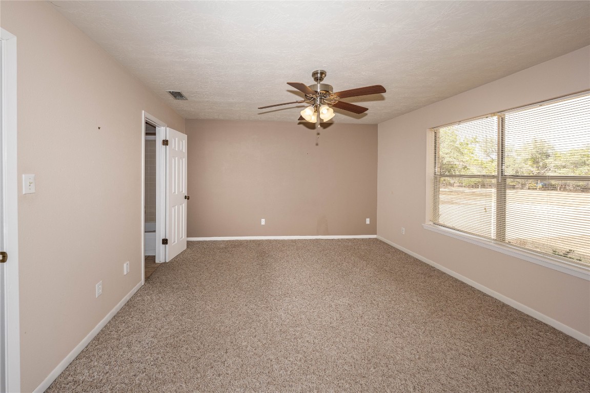 2501 Fischer Store Road Wimberley, TX 78676 - Photo 21 of 37 Carpeted empty room featuring a textured ceiling and ceiling fan