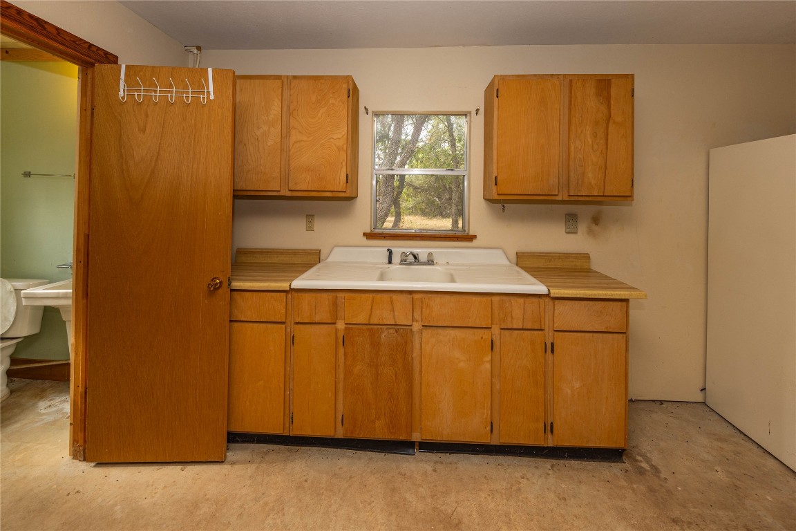 2501 Fischer Store Road Wimberley, TX 78676 - Photo 30 of 37 Kitchen with light countertops, brown cabinets, and concrete flooring