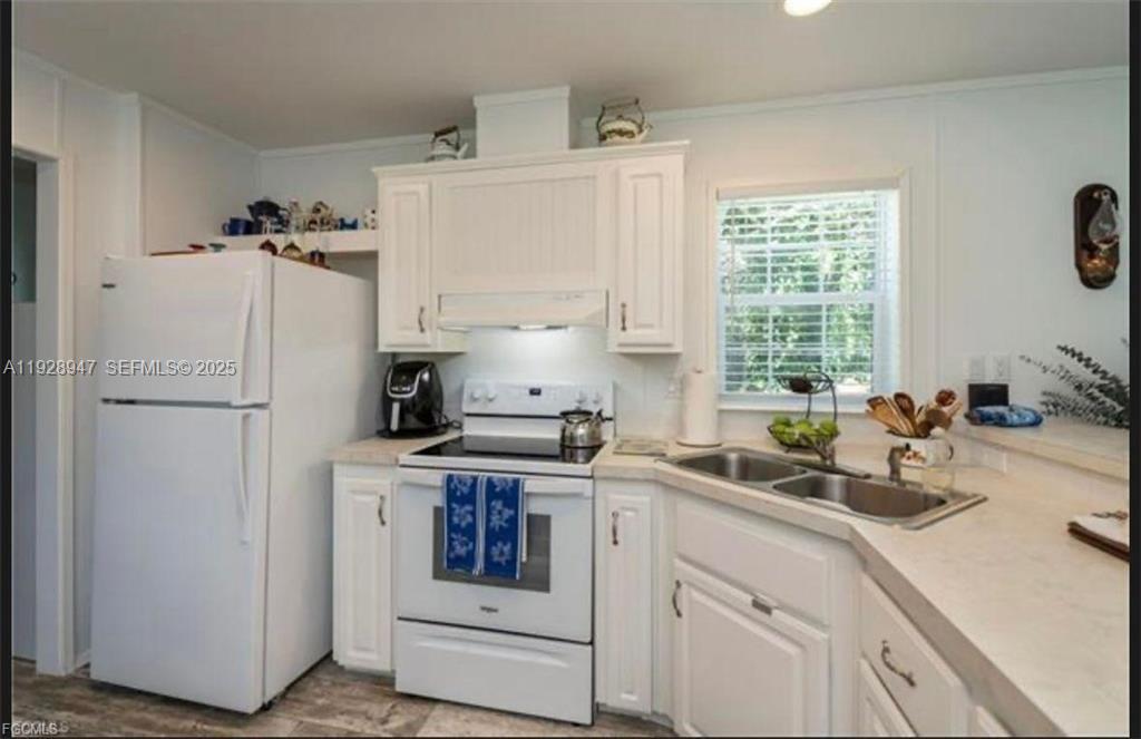 2638 Ortona Locks Road Moore Haven, FL 33471 - Photo 10 of 14 a kitchen with white cabinets and white appliances