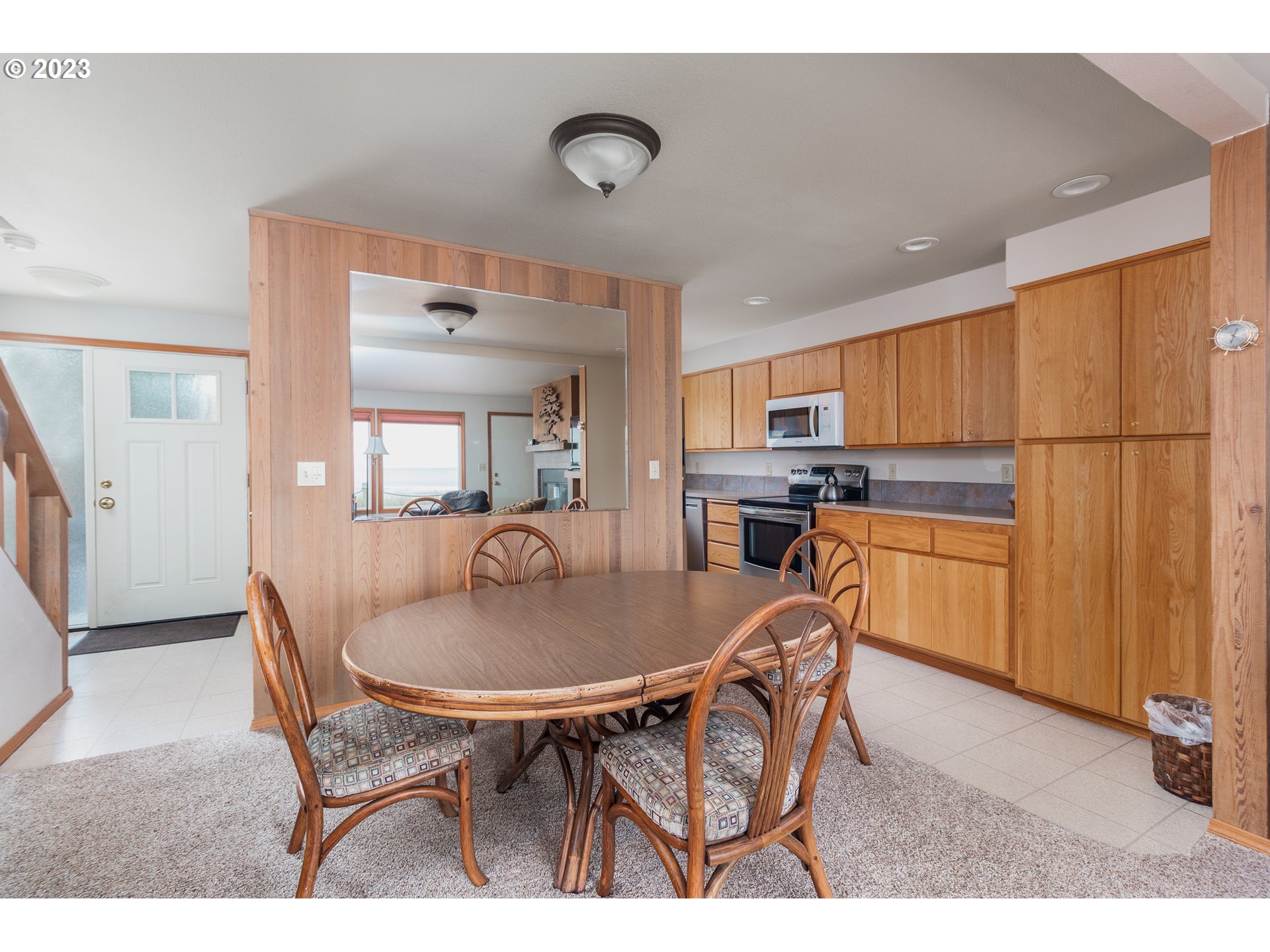48060 Breakers Boulevard, Unit 2 Neskowin, OR 97149 - Photo 8 of 26 a kitchen with stainless steel appliances kitchen island granite countertop a dining table chairs and granite counter tops