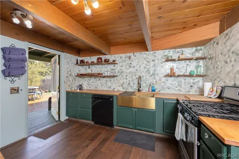 a kitchen with stainless steel appliances granite countertop a stove and a wooden floors