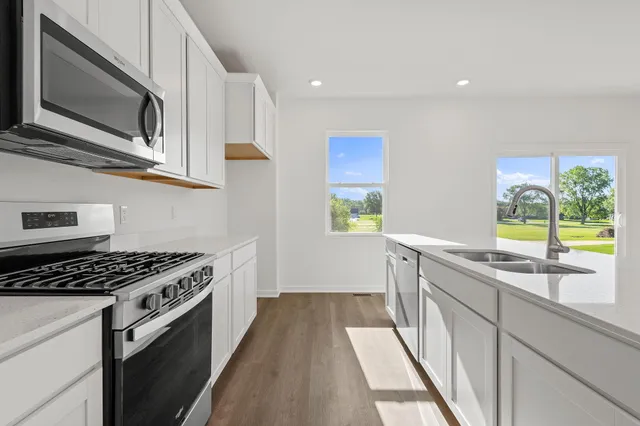 a kitchen with stainless steel appliances a stove a sink and a microwave