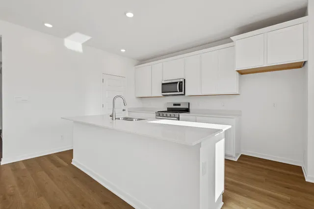 a kitchen with a sink a stove a microwave and cabinets