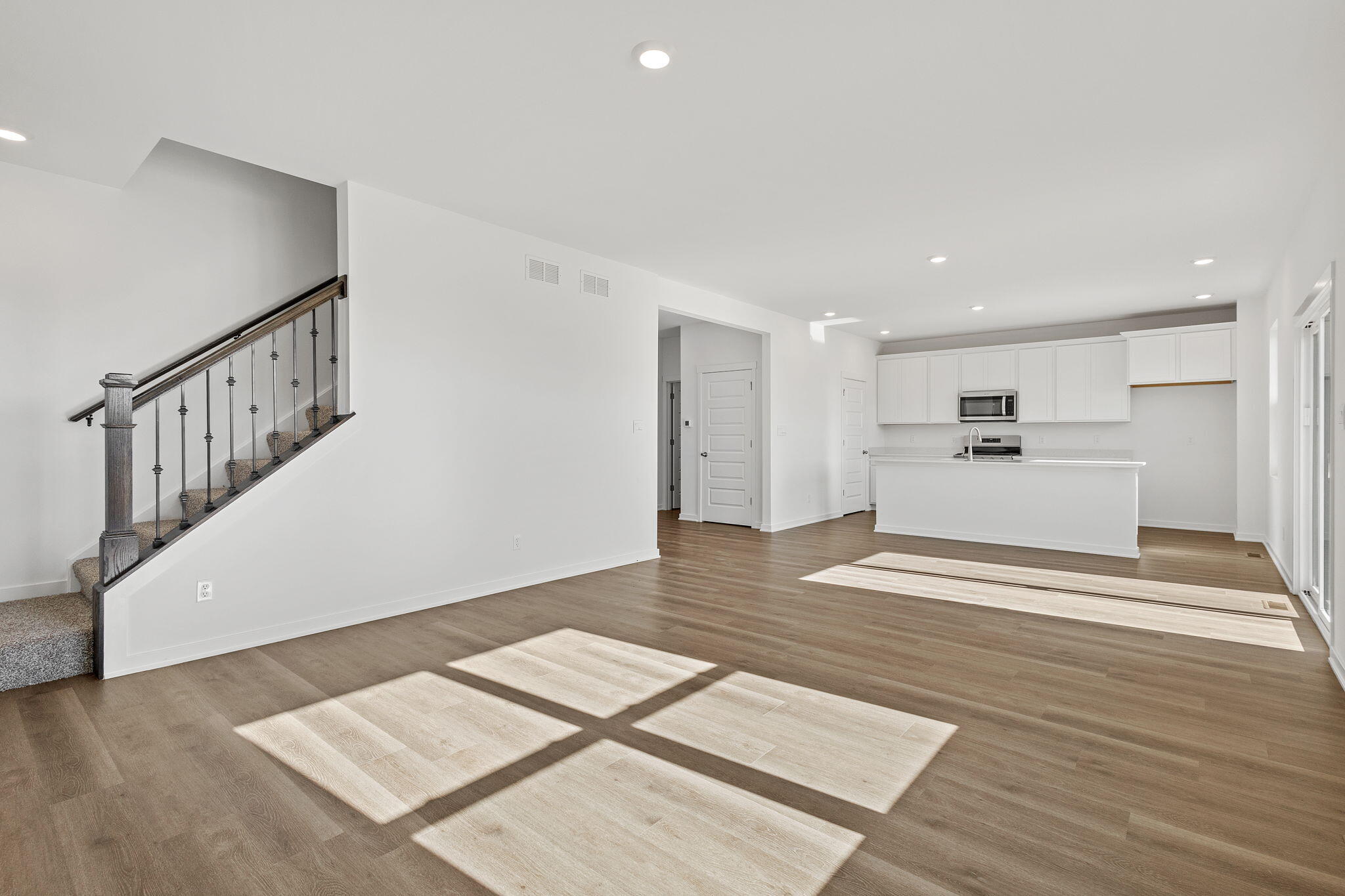 7770 West 106th Lane Crown Point, IN 46307 - Photo 6 of 25 a view of an empty room with wooden floor and stairs