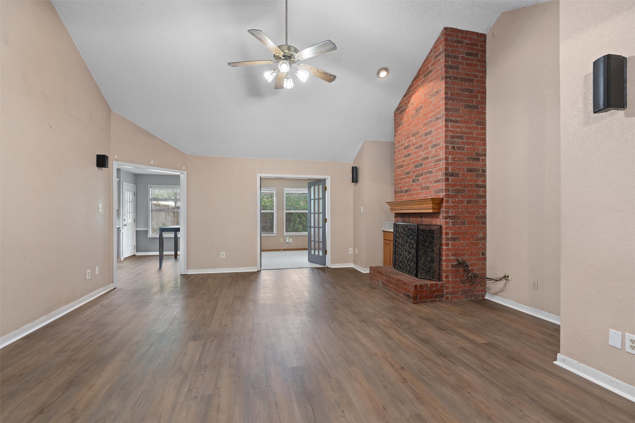2306 Raintree Path Round Rock, TX 78664 - Photo 2 of 23 A spacious living area showcasing a prominent brick fireplace and rich hardwood flooring.