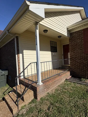 a view of a porch with furniture and floor to ceiling window