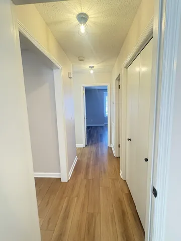 a view of a hallway with wooden floor