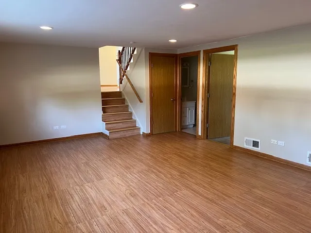 an empty room with wooden floor and entryway