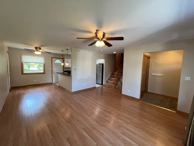 a view of an empty room with window and wooden floor