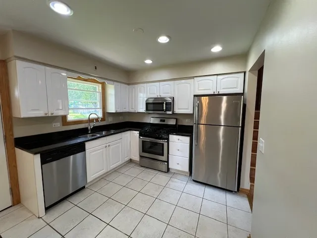 a kitchen with granite countertop a refrigerator and a sink