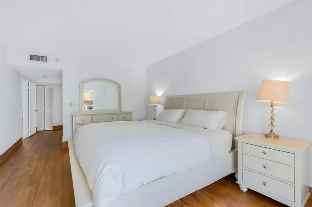 a spacious bedroom with a bed and a dresser