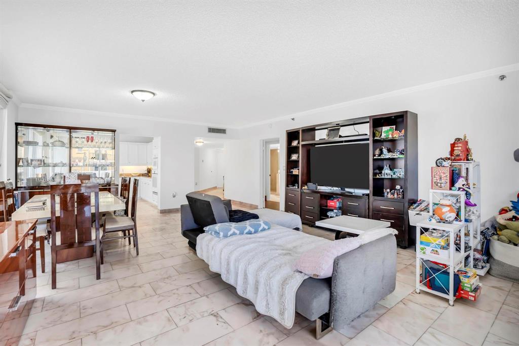 8855 Collins Avenue, Unit 2D Surfside, FL 33154 - Photo 5 of 25 a living room with furniture and a flat screen tv